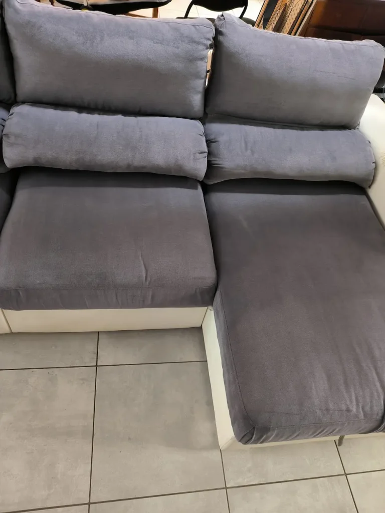 Canapé confortable en tissu gris avec coussins.